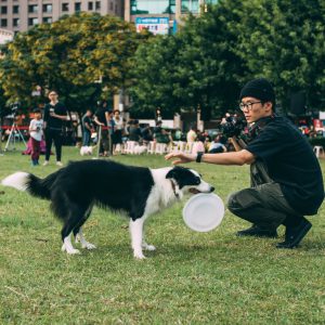 man holding black and white dog